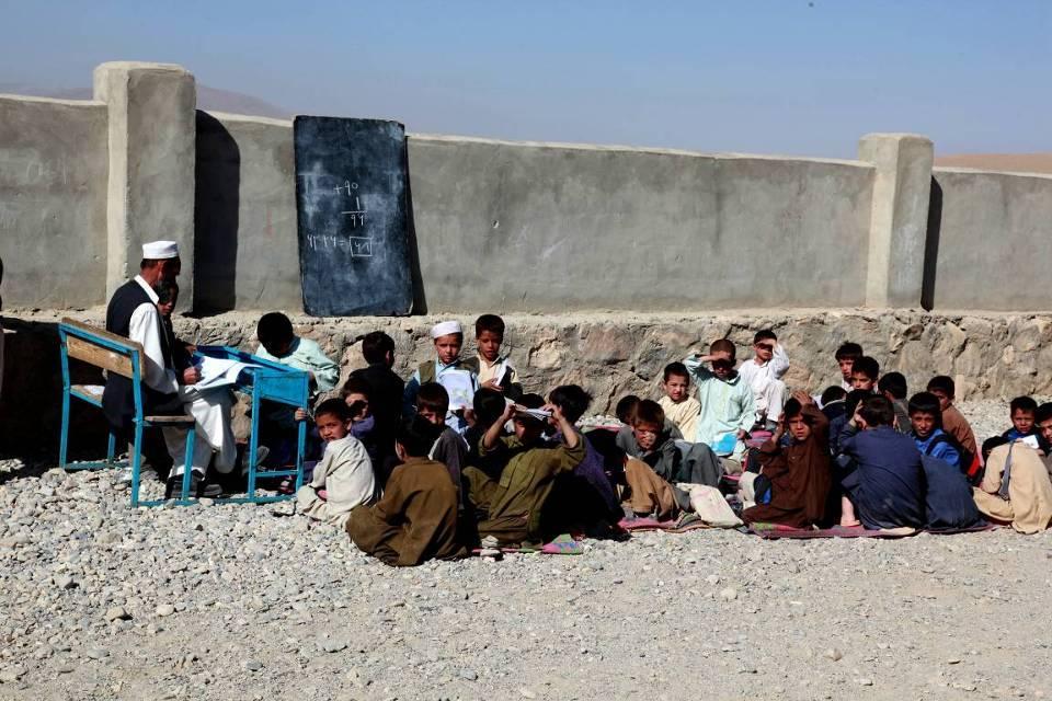 An Afghan instructor teaches students outside a schoolhouse in Logar Province, Afghanistan,
