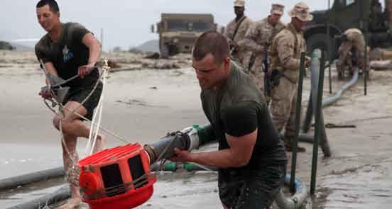 produce approxi- Marines with CLB-15, 15th MEU, move a pump into the ocean during a water purification operation at Red Beach, April 5.