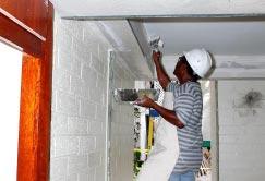 Thirteen units to be renovated this year... (From page 1) (Photo by KW Hillis) Carpenter Anilang Bedinin applies plaster to a newly installed central air duct in Qtrs. 464-B.