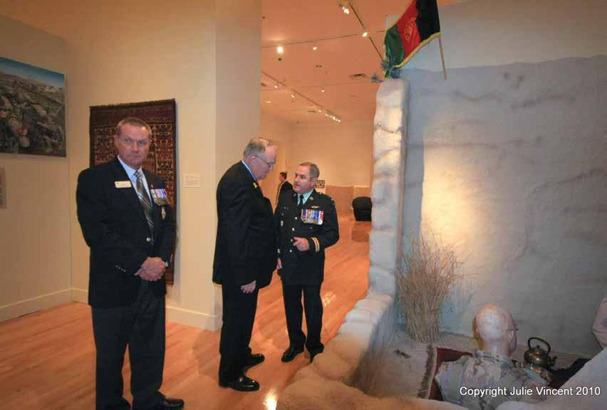 The R Adjt briefing the Lieutenant Governor as Director TMM looks on Of note in this photo is the diorama built by two infantry NCOs and a painting by Roger Chabot who served with the First Battalion