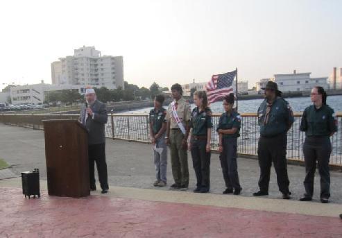 Boy Scouts and Venture Crew members watch as Junior Scouts conducting Flag Retirement Ceremony. Vice Commander David Singer of Post 1054 addresses those in attendance.