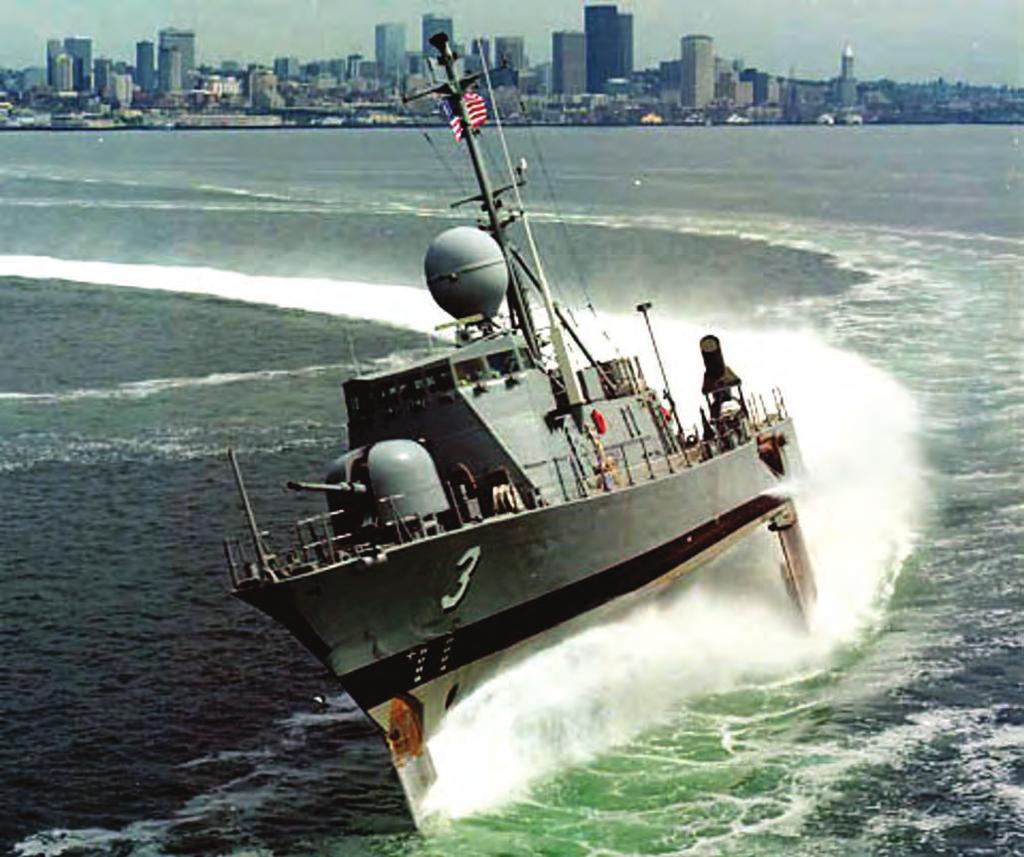The Boeing Patrol Hydrofoil Missile U.S.S. TAURUS (PHM-3) takes a high-speed turn on her underwater foils during sea trials in 1977, on Elliott Bay, in Seattle.