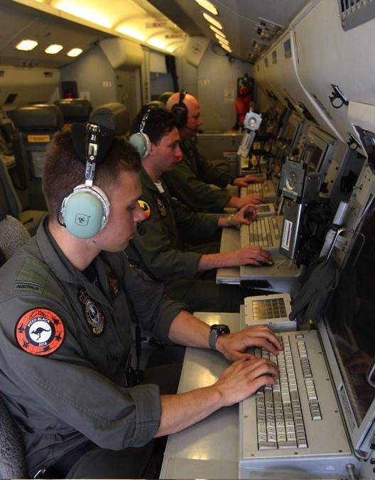 FIGURE 15 AIR COMBAT OFFICERS, PILOT OFFICERS NELSON (FOREGROUND) AND BRAYDEN, AND NO 2 SQUADRON DETACHMENT COMMANDER, SQUADRON LEADER SAMUEL THORPE, CONDUCT A PRE-FLIGHT CHECK IN THE E-7A WEDGETAIL