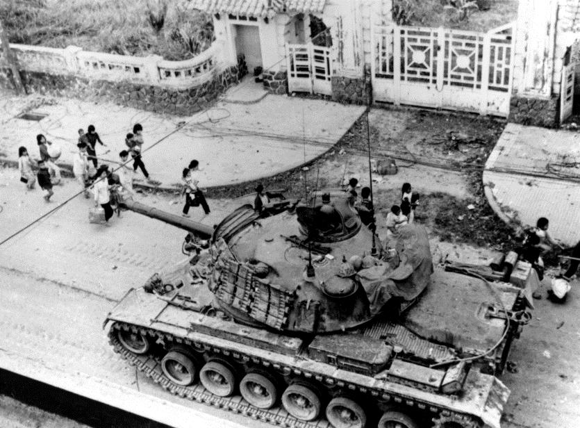 1st ARVN Division Right: Refugees pass by a supporting tank as it moves up the street