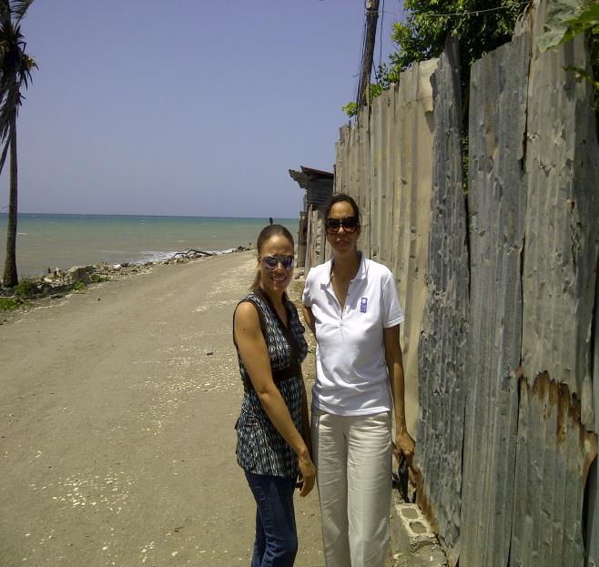 Shirley and Margaret Jones Williams of UNDP at the zinc perimeter of houses in the seaside community