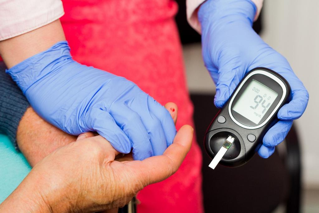 How should blood glucose meters be cleaned and disinfected?