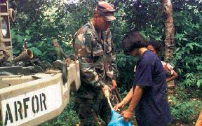 Chapter II Army water purification specialist fills a jug for a resident of La Libertad, Honduras during Hurricane MITCH relief efforts.