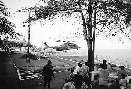 Historical Noncombatant Evacuee Operations Figure A-4. A helicopter landing at the Embassy in Monrovia Figure A-5. Special Forces Soldiers escort evacuees from a transportation station A-11.