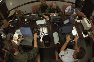 Officers and enlisted members of Tyndall s Tabulation and Verification Office review computerized score sheets used during the