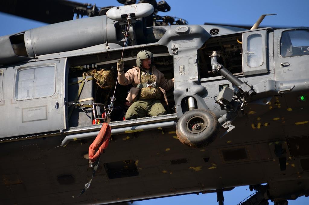 SMSgt. John Louden, 301st Rescue Squadron, prepares to lower a rescue strop as the HH-60 Pave Hawk positions above a rooftop during Katrina-like flood training March 8, 2015 in Perry, GA.