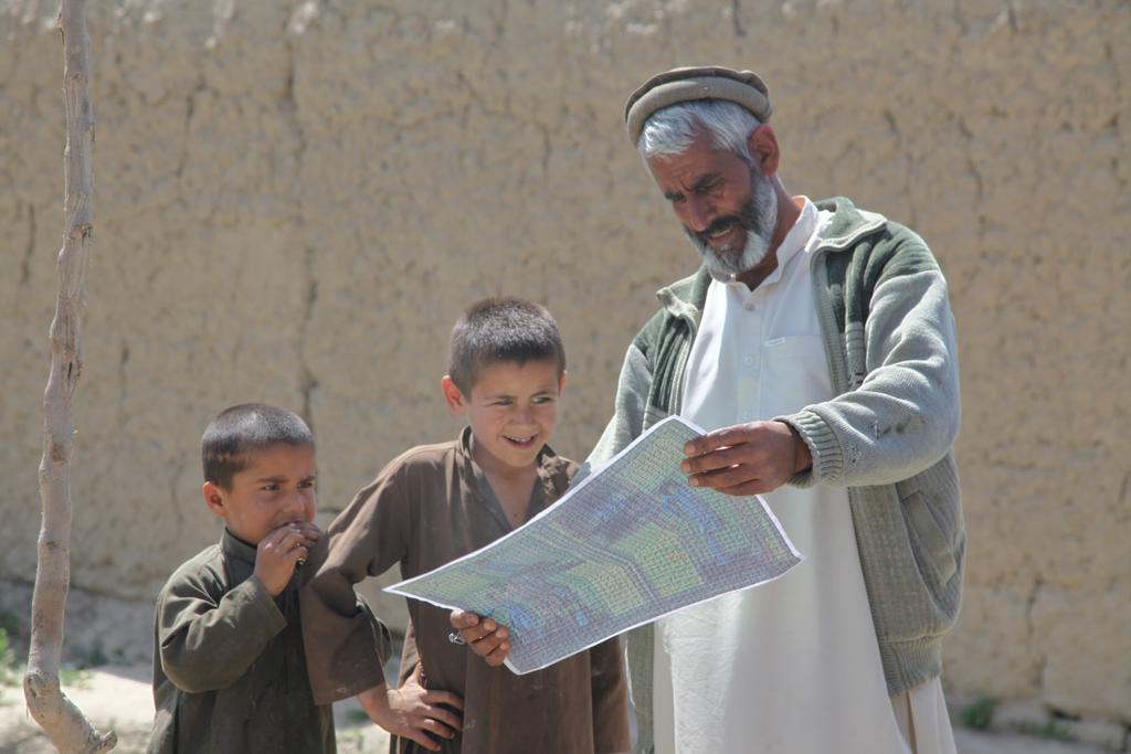 Apache Troop 1-75 Conducts Route Clearance Afghan local nationals look at a poster that was given to