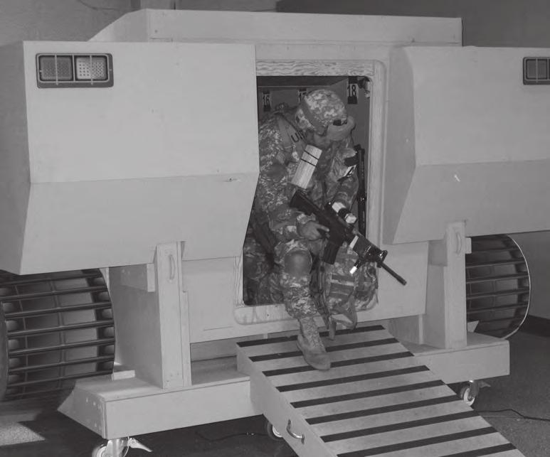 A Soldier wearing MOPP gear and protective mask exits an ICV mock-up with its ramp open during a demonstration at the Santa Clara BAE Systems facility. (U.S. Army photo courtesy of FCS(BCT).