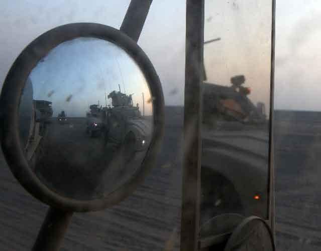 Chad Wadsworth, a military policeman, load a trailer on the back of a Logistics Vehicle System Replacement at Forward