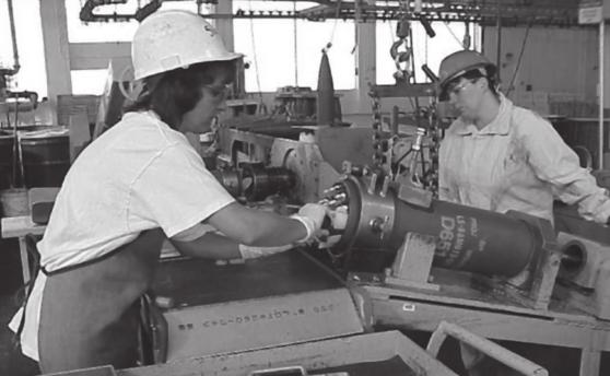 An 8 artillery projectile is placed in its carousel by an MCAAP explosive worker prior to being lowered into an autoclave.