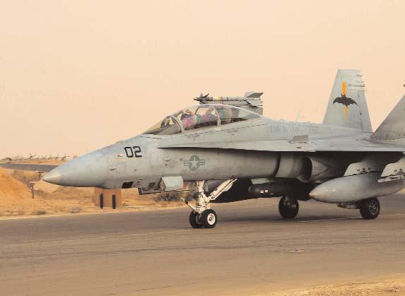 Above, a squadron F/A-18D equipped with the Advanced Tactical Airborne Reconnaissance System taxis at Al Asad, Iraq, on 30 October 2004. Right, VMFA(AW)-242 imagery analyst Sgt.