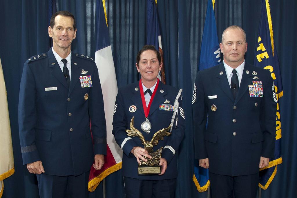 Tech. Sgt. Jamie Jones, center, holds her award for Air National Guard s 2013 Outstanding Airman of the Year, which was presented to her by the Director of the Air National Guard, Lt. Gen. Stanley E.