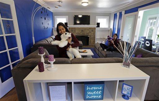 and her twin sister, Karishma Mandyam, sit in the living room of the 3,100-square-foot home they share rent-free with six other female University of Washington computer science and technology