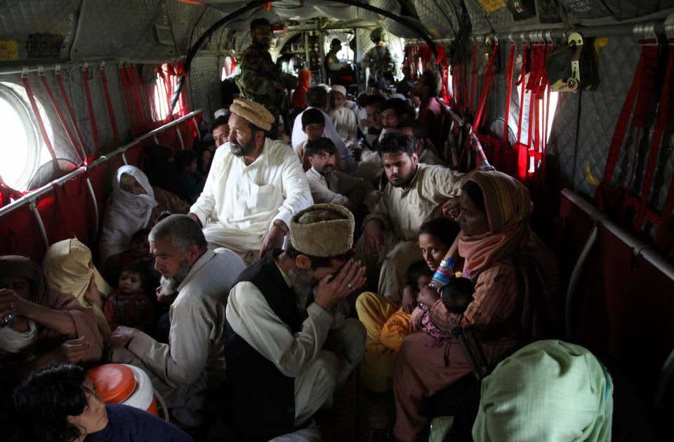 Pakistani victims of the flooding are seated on the floor of a U.S.