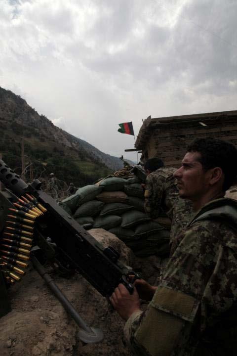 An Afghan National Army (ANA) Soldier of the 201st ANA Corps stands on watch in his fighting position outside the town of Barge Matal as part