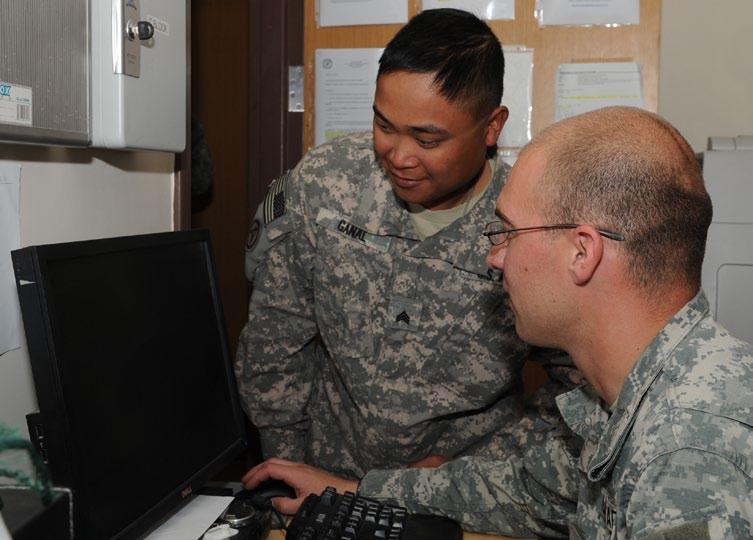 Sgt. Clyde Linker, right, billeting noncommissioned officer in charge, 196th Maneuver Enhancement Brigade, South Dakota Army National Guard, helps a customer with room arrangements Sept.
