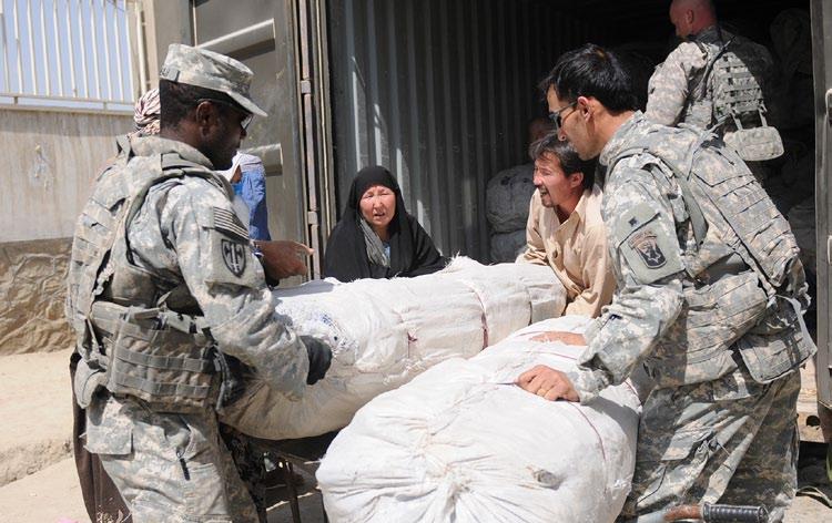 Soldiers of Golf Company, 186th Brigade Support Battalion, Vermont Army National Guard, assist a family with tents and food supplies during the delivery of humanitarian aid Sept.