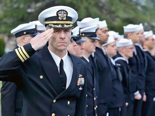 Cmdr. Kelly Laing, commanding officer of the USS Maine, salutes during the national anthem and presentation of colors at a memorial Dick Turpin on Friday at Ivy Green Cemetery in Bremerton.