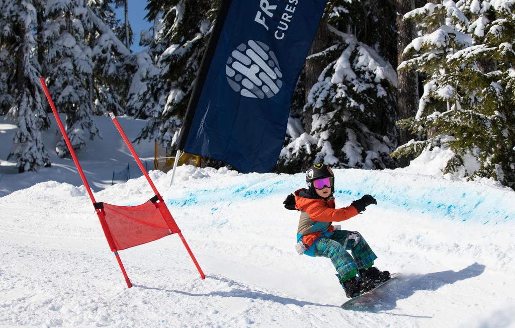 A snowboarder rides the Slayride Banked Slalom at Stevens Pass having fun while raising funds for Fred Hutch.