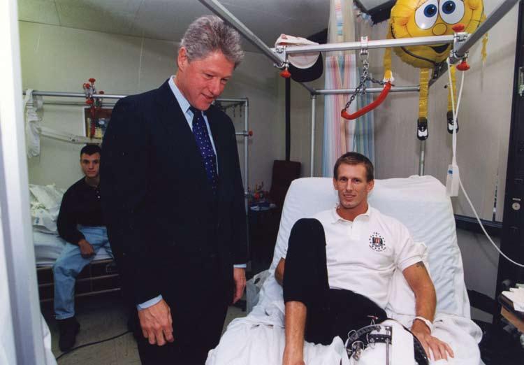 p President Bill Clinton visiting a soldier wounded in Somalia.