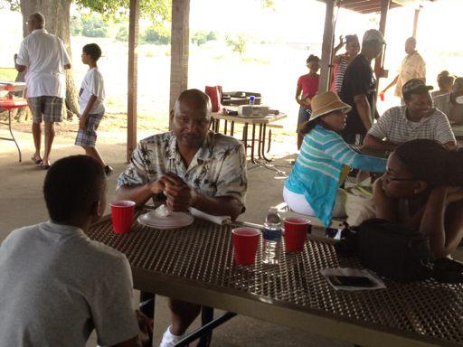 Tidewater NNOA President Cdr. Terrel Fisher talks with a young student about educational and career opportunities during the 7 th annual joint cookout.