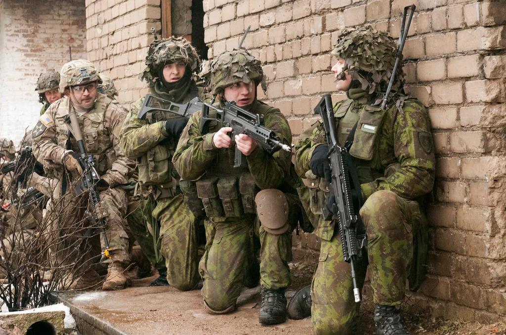 Lithuanian soldiers alongside U.S. troops from 3/2 CR prepare to enter and clear a building during an exercise at Pabrade Training Area, Lithuania, on 26 February 2015.
