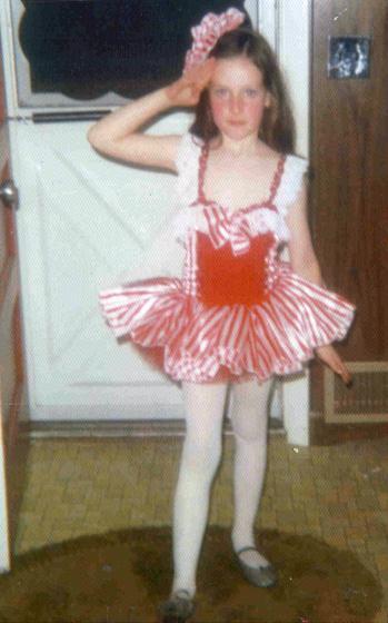 Page 9 WHO AM I? CLUE: "Here I am at age 5, all dressed for my dance recital.