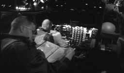 ABCCC workstations (below) glow and hum away inside the capsule. At right, the flight deck crew reviews the checklist, preparing for a new sortie.