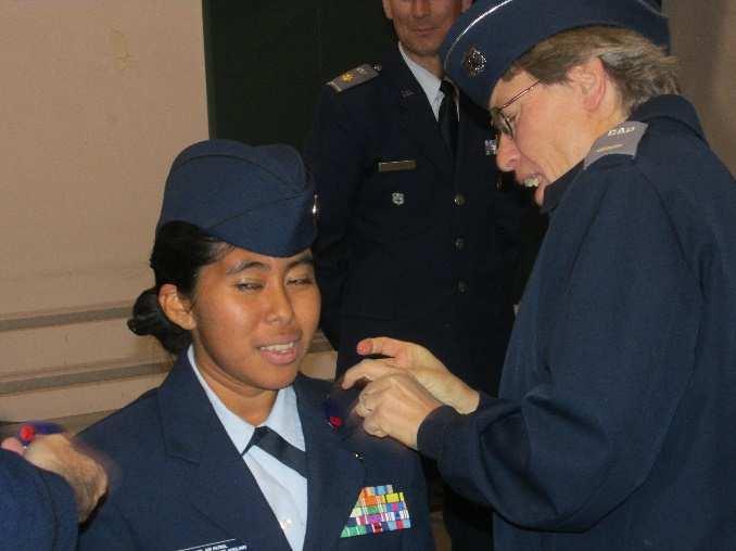 Bottom Right: Juana Fox is promoted to cadet chief master sergeant, assisted by her