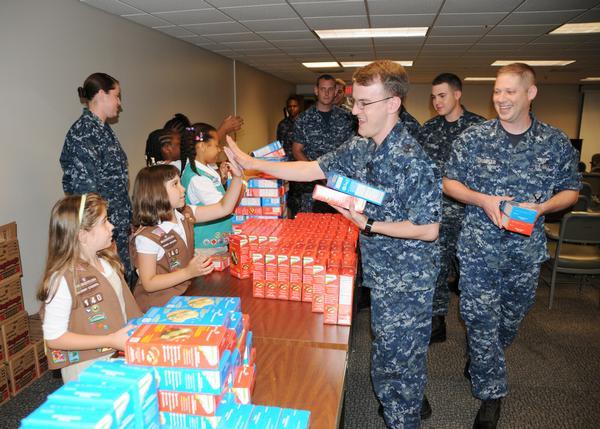 Aviation Electronics Technician 3rd Class Dylan Daly "high fives" Girl Scout Jordan Varrasse in appreciation for cookies she gave to him and other military personnel at Fleet Readiness Center