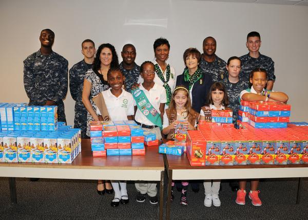 On June 18, Girl Scouts of Gateway Council in Jacksonville prepare to distribute free cookies to Sailors assigned at Hangar 1000 during a visit to Fleet Readiness Center Southeast (FRCSE), an